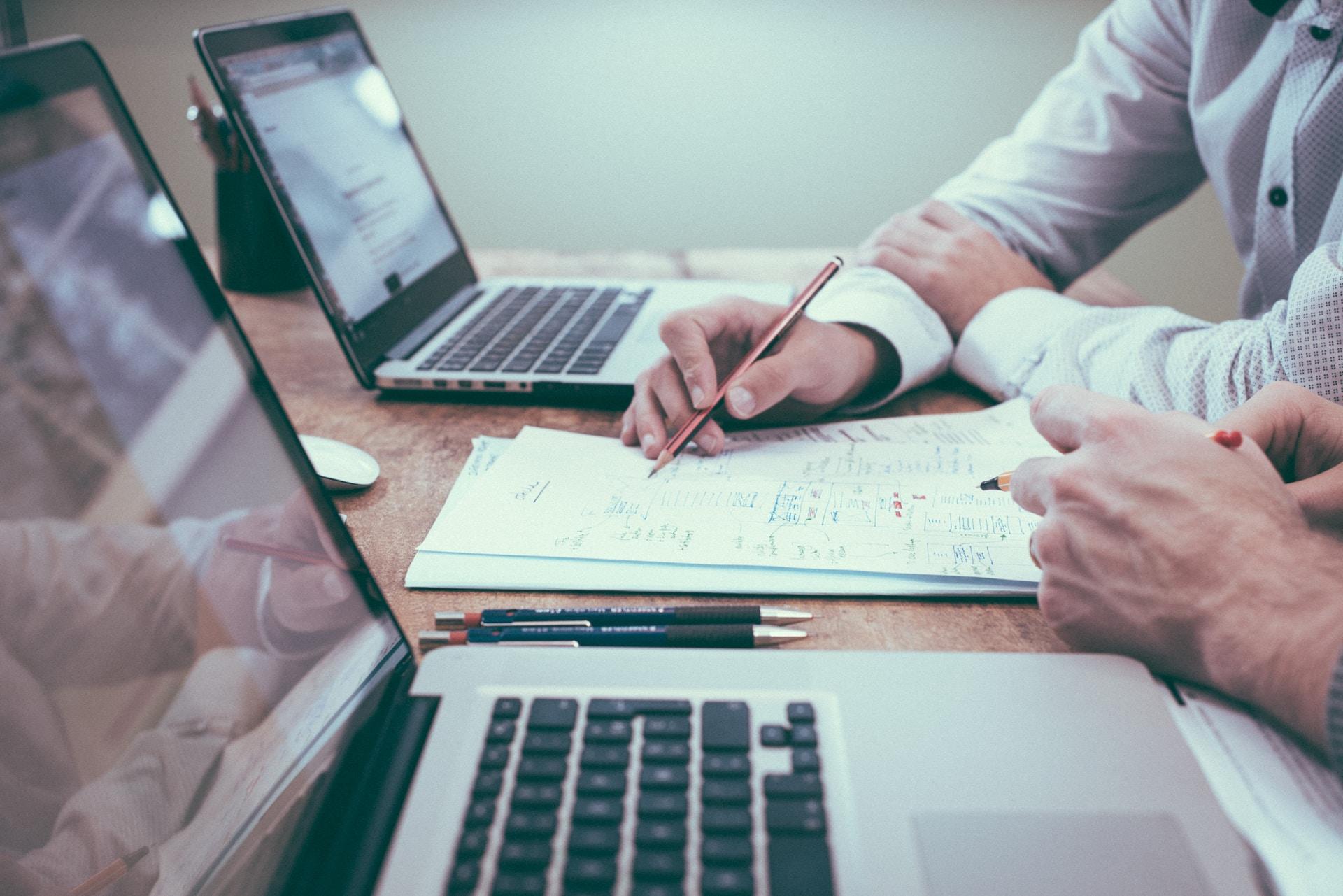 Persone al lavoro su computer e documentazione Persone al lavoro su computer e documentazione